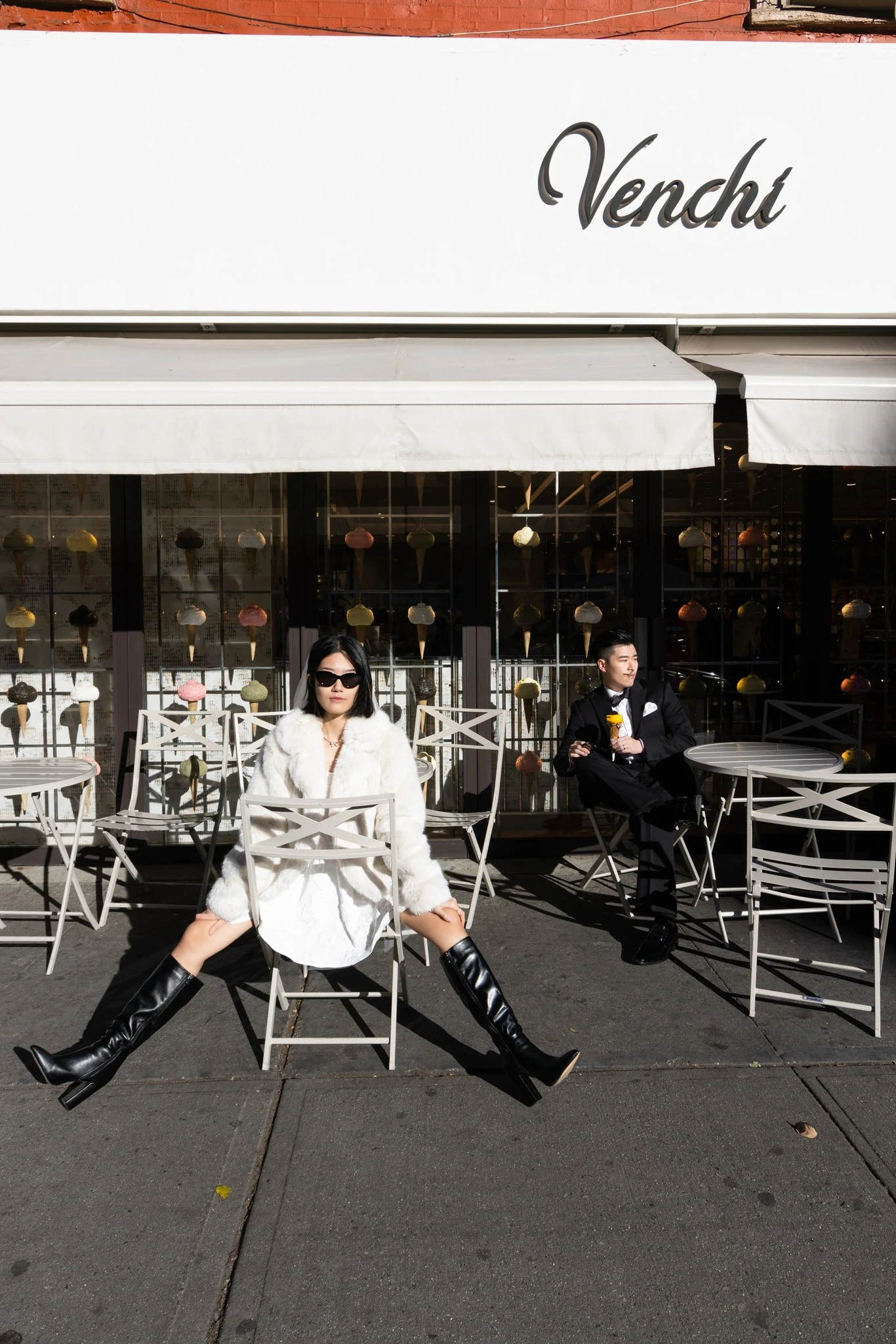 Xike and a companion seated outside a street-side café